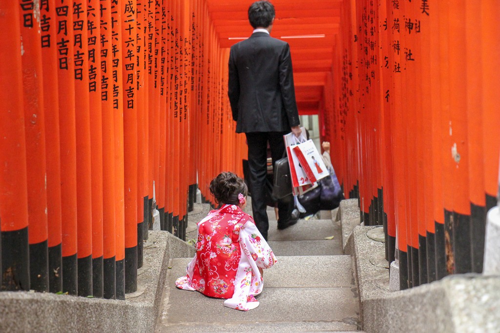 Little girl dressed in kimono on stairs under torii gates at Hie Shrine in Tokyo, Japan